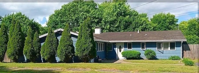 view of front of house with a chimney, a front lawn, and fence