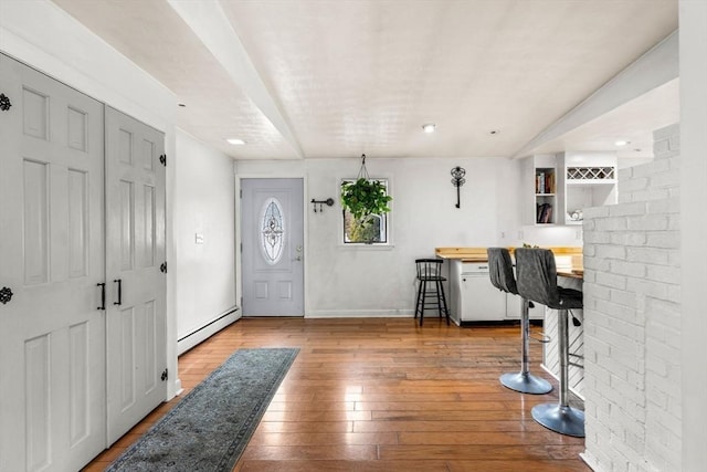 foyer featuring hardwood / wood-style flooring, baseboards, and a baseboard radiator