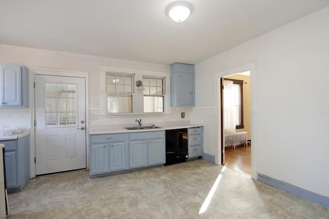 kitchen featuring a sink, light countertops, backsplash, radiator, and dishwasher