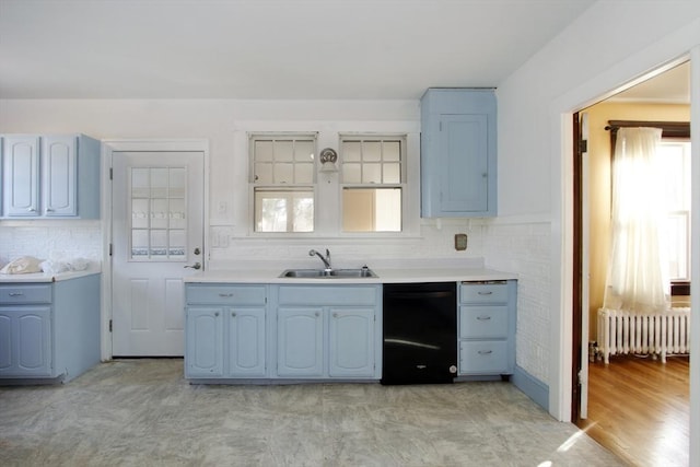 kitchen featuring dishwasher, light countertops, a sink, and radiator heating unit