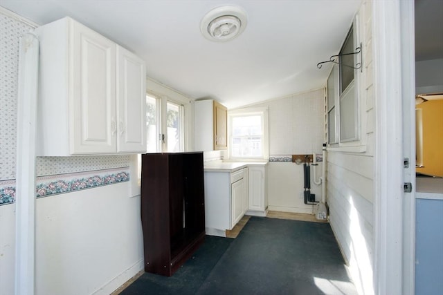 kitchen with white cabinetry, vaulted ceiling, and light countertops