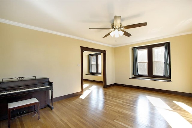 empty room with baseboards, ornamental molding, ceiling fan, and wood finished floors