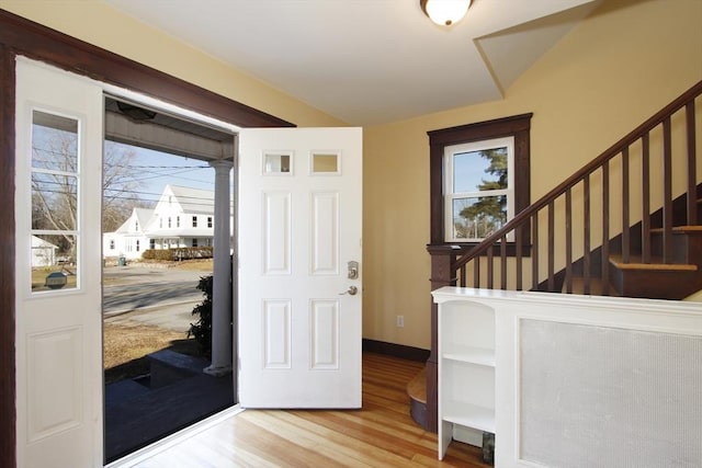 entryway with stairway, wood finished floors, and baseboards