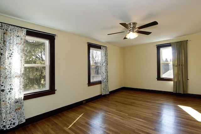 empty room featuring a ceiling fan, baseboards, and wood finished floors