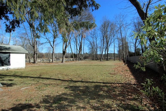 view of yard featuring fence and an outdoor structure