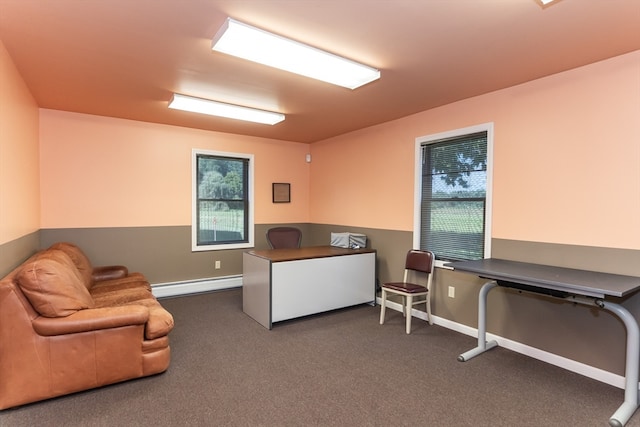 office area featuring a baseboard heating unit, plenty of natural light, and dark colored carpet