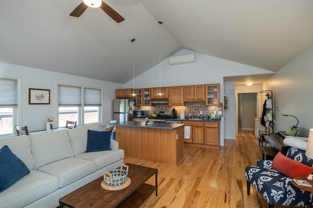 living room featuring a healthy amount of sunlight, ceiling fan, light hardwood / wood-style flooring, and high vaulted ceiling