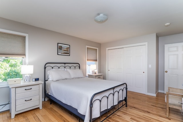 bedroom featuring a closet, a baseboard radiator, and light hardwood / wood-style flooring