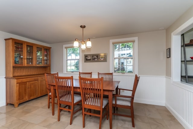 tiled dining area featuring a wealth of natural light and a notable chandelier