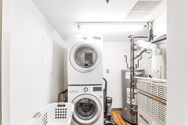 clothes washing area with gas water heater, laundry area, and stacked washer and clothes dryer