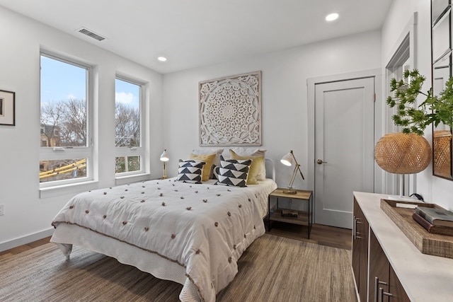 bedroom featuring hardwood / wood-style floors and multiple windows