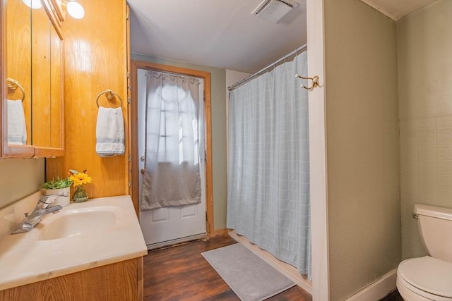 bathroom with vanity, hardwood / wood-style flooring, toilet, and walk in shower