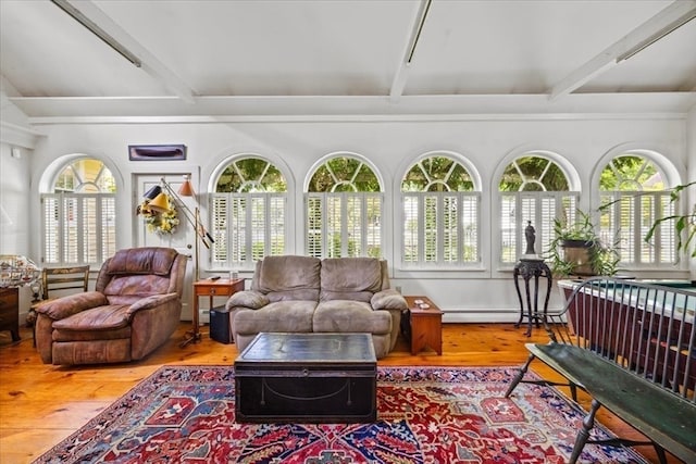 sunroom / solarium featuring beamed ceiling and a baseboard radiator