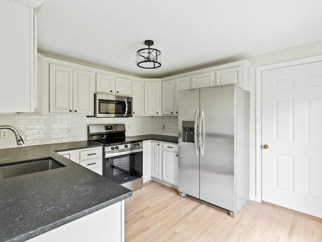 51 Old Stagecoach Rd, Attleboro, MA 02703 - kitchen featuring stainless steel appliances, a sink, tasteful backsplash, light wood-style flooring, and white cabinetry