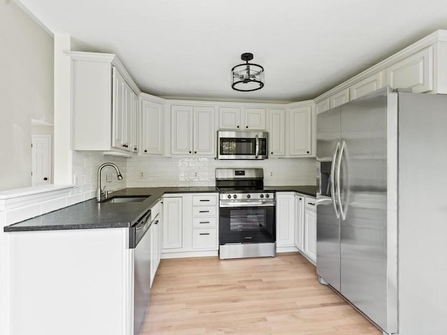 51 Old Stagecoach Rd, Attleboro, MA 02703 - kitchen featuring stainless steel appliances, a sink, dark countertops, tasteful backsplash, and light wood finished floors