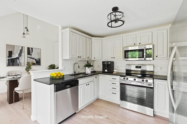 51 Old Stagecoach Rd, Attleboro, MA 02703 - kitchen with stainless steel appliances, light wood-style flooring, a sink, tasteful backsplash, and a chandelier