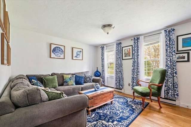 59 Brigantine Cir, Plymouth, MA 02360 - living area with light wood-style flooring, a textured ceiling, baseboard heating, and baseboards