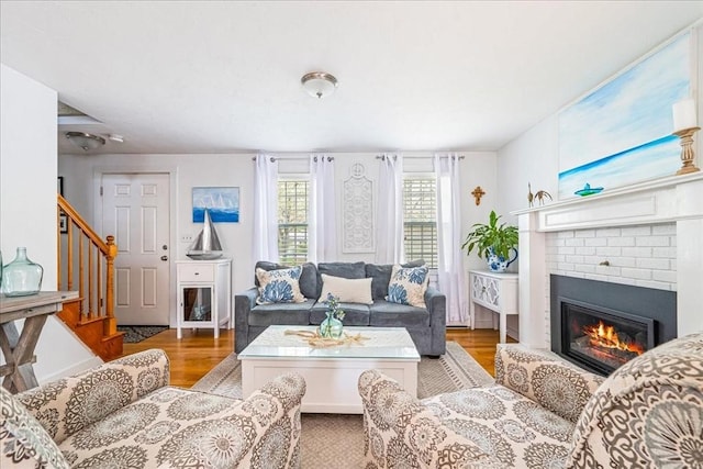 59 Brigantine Cir, Plymouth, MA 02360 - living room with stairs, wood finished floors, a brick fireplace, and baseboards