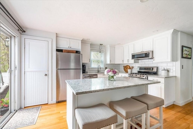 59 Brigantine Cir, Plymouth, MA 02360 - kitchen with appliances with stainless steel finishes, light wood-style floors, backsplash, and a sink