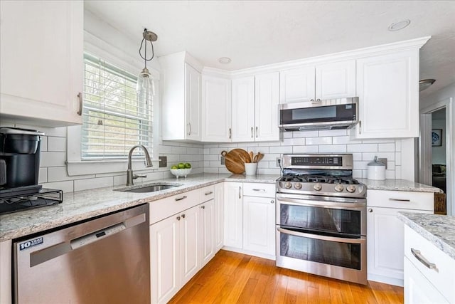 59 Brigantine Cir, Plymouth, MA 02360 - kitchen with stainless steel appliances, a sink, white cabinetry, and decorative backsplash
