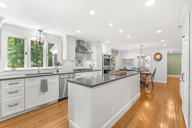 80 Christian Way, North Andover, MA 01845 - kitchen with appliances with stainless steel finishes, wall chimney exhaust hood, light wood finished floors, a kitchen island, and white cabinets