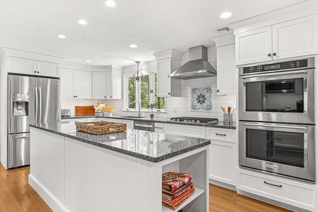 80 Christian Way, North Andover, MA 01845 - kitchen with appliances with stainless steel finishes, wall chimney range hood, open shelves, light wood-style floors, and white cabinetry