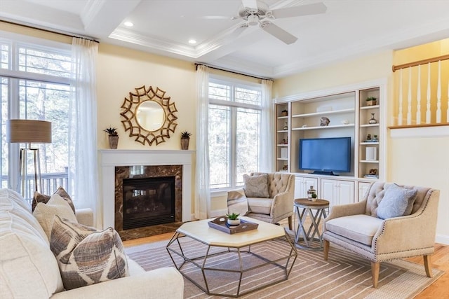 living room featuring beamed ceiling, ornamental molding, coffered ceiling, and light wood-type flooring