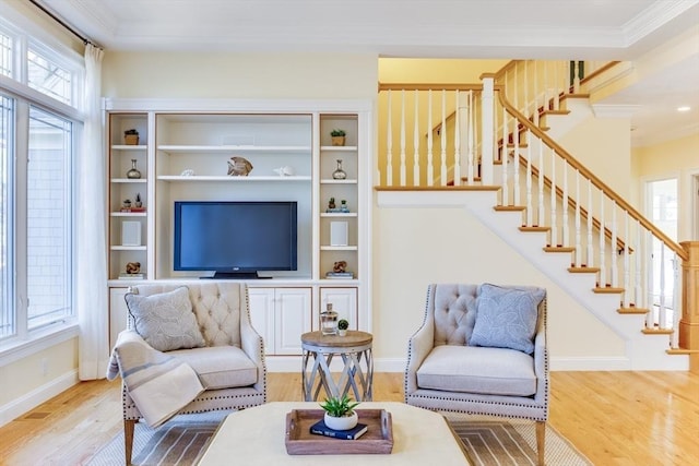 living room featuring ornamental molding, a healthy amount of sunlight, and wood-type flooring