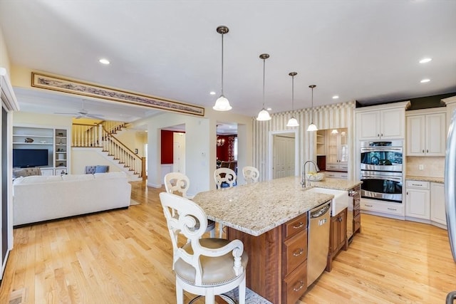 kitchen with white cabinetry, an island with sink, appliances with stainless steel finishes, and sink