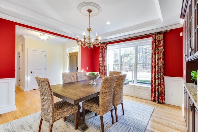 dining space featuring crown molding, a notable chandelier, and light wood-type flooring