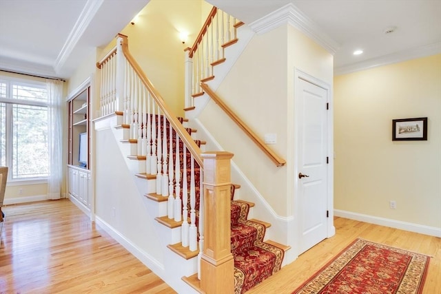 stairs with hardwood / wood-style flooring and ornamental molding