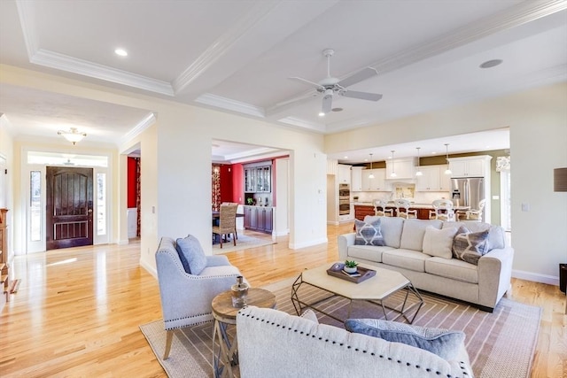 living room featuring crown molding, light hardwood / wood-style flooring, and ceiling fan