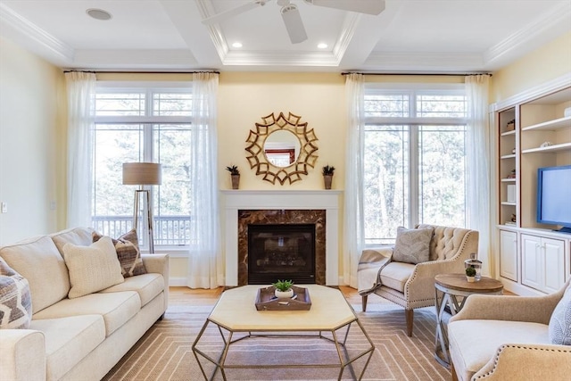 living room featuring coffered ceiling, crown molding, light wood-type flooring, beamed ceiling, and a premium fireplace