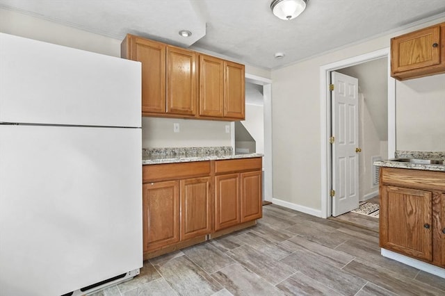 13 Hoyt Ave, Amesbury, MA 01913 - kitchen featuring freestanding refrigerator and brown cabinetry