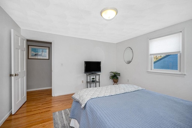 bedroom with baseboards and light wood-type flooring