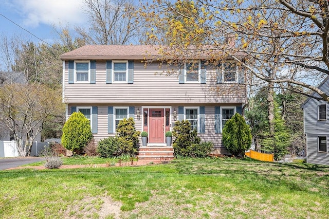 colonial-style house with a front lawn and fence