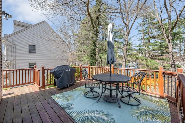 wooden deck with a grill and outdoor dining space