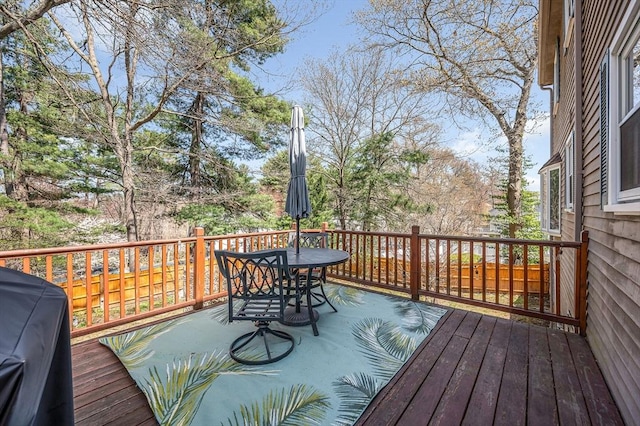 deck featuring outdoor dining area and a grill