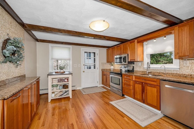 kitchen with stainless steel appliances, tasteful backsplash, beam ceiling, and a sink