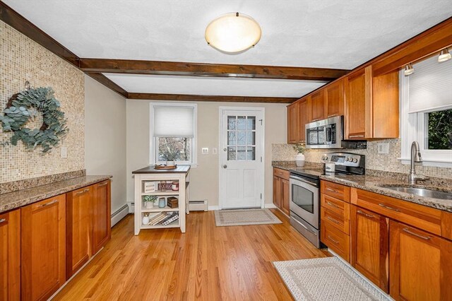 kitchen with stainless steel appliances, tasteful backsplash, a baseboard heating unit, and a sink