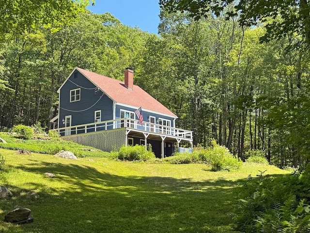 233 Old Wendell Rd, Northfield, MA 01360 - back of property featuring a deck, a chimney, a lawn, and a wooded view