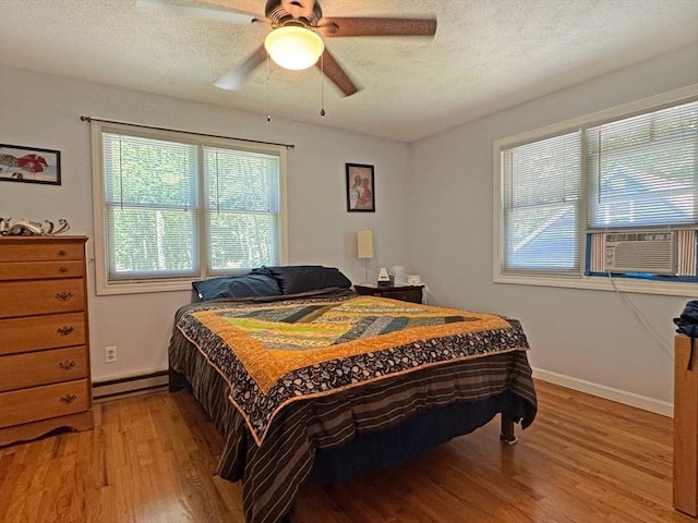 233 Old Wendell Rd, Northfield, MA 01360 - bedroom featuring light wood-style floors, baseboard heating, cooling unit, a textured ceiling, and a ceiling fan