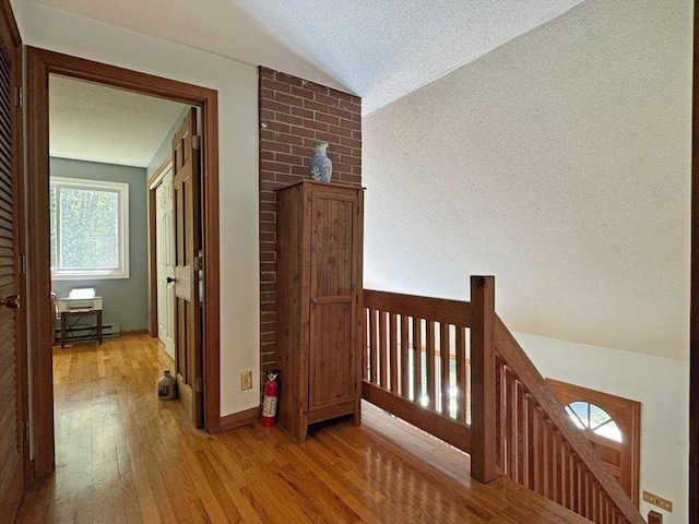 233 Old Wendell Rd, Northfield, MA 01360 - corridor featuring wood finished floors, a textured ceiling, an upstairs landing, vaulted ceiling, and baseboard heating