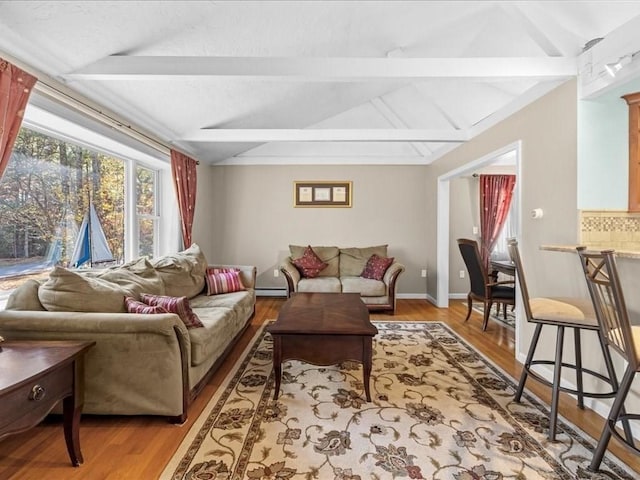 living area with baseboards, baseboard heating, wood finished floors, and vaulted ceiling with beams