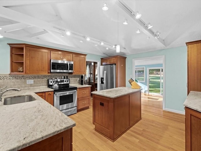 kitchen with lofted ceiling, open shelves, a sink, appliances with stainless steel finishes, and a center island