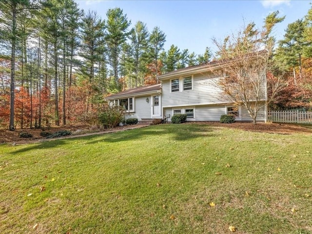 split level home featuring fence, a front yard, and entry steps