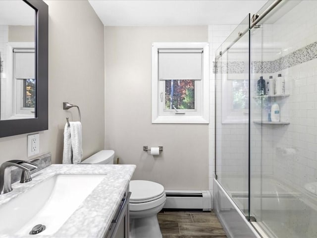 bathroom featuring vanity, wood tiled floor, a baseboard radiator, bath / shower combo with glass door, and toilet