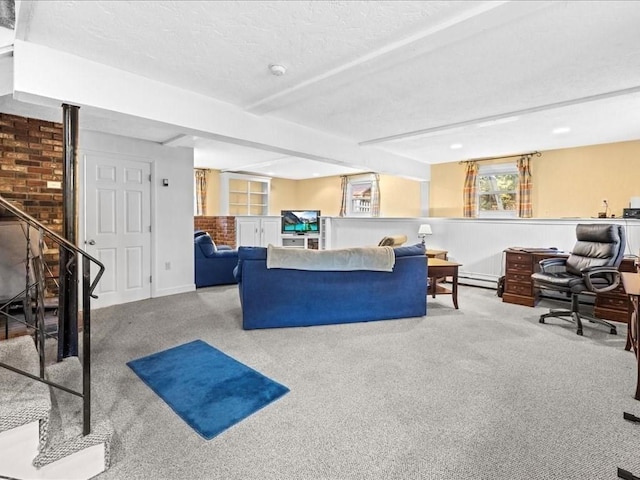 living room with beamed ceiling, carpet, and a textured ceiling