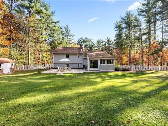 rear view of house with a lawn, a fenced backyard, and a patio area