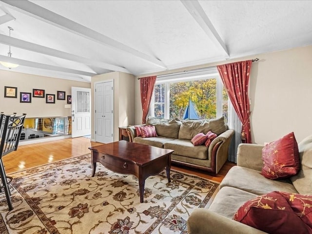 living room featuring beam ceiling, a textured ceiling, and wood finished floors